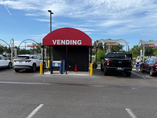 Free self-service vacuum stations at River Club Car Wash, with a covered central vending area flanked by open vacuum bays